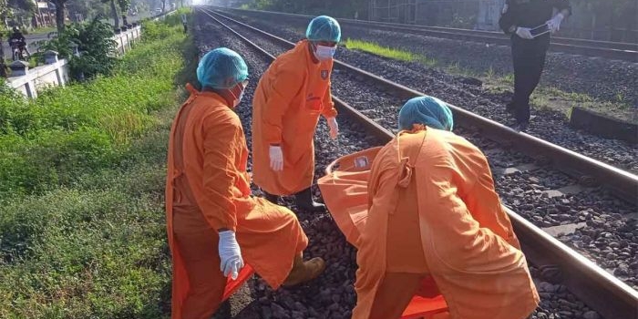 Polisi saat mengevakuasi potongan tubuh korban di perlintasan kereta api.