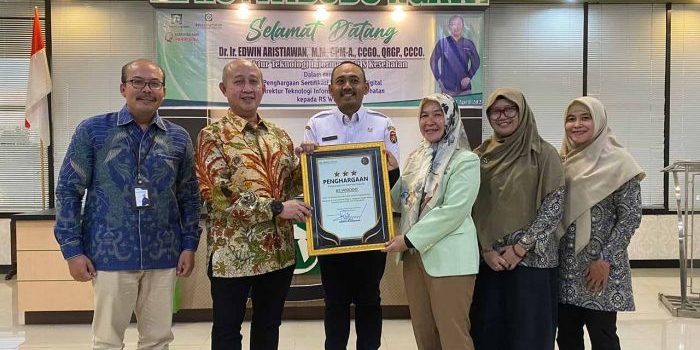 Direktur Teknologi Informasi (TI) BPJS Kesehatan, Eswin Aristiawan memberikan penghargaan kepada kepala RS Widodo Ngawi. Foto: Dok BPJS Kesehatan.