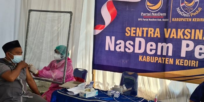 Salah satu peserta vaksinasi massal Partai NasDem sedang disuntik petugas. (foto: ist)