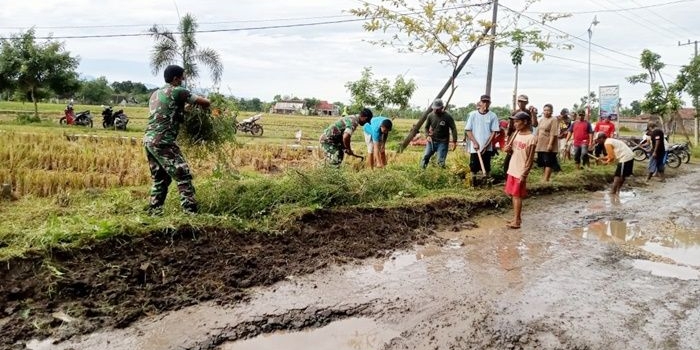 Anggota Babinsa bersama warga Desa Rejuno sedang bergotong royong membersihkan aliran sungai/parit.