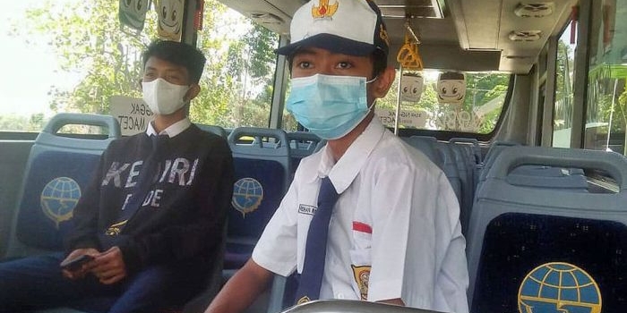 Dua orang siswa saat naik bus sekolah gratis yang disediakan oleh Pemkot Kediri. Foto: Ist