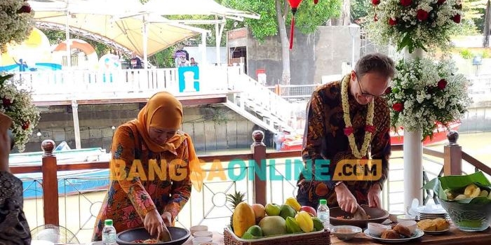 Gubernur Khofifah saat menunjukkan kepiawaiannya membuat rujak manis di hadapan Duta Besar Inggris, Dominic Jermey. Foto: DEVI FITRI AFRIYANTI/BANGSAONLINE