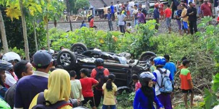 Mobil Daihatsu Terios yang hancur setelah diseruduk kereta api jadi tontonan warga. (foto: tri susanto/BANGSAONLINE)