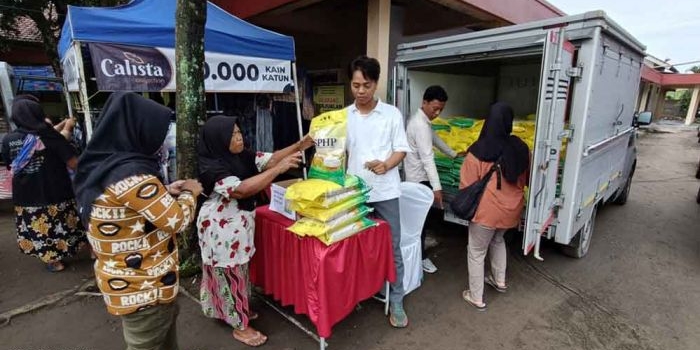 Petugas Bulog saat melayani masyarakat yang hendak membeli beras murah. (Ist)