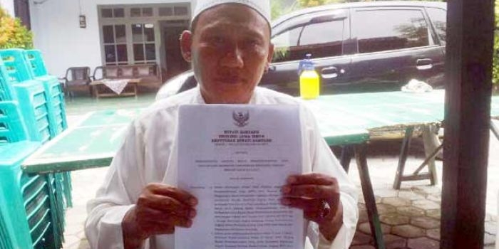 Ketua BPD Desa Ragung H Rowit menunjukkan SK pemecatan 7 anggota BPD oleh Bupati Sampang yang dinilai cacat prosedural.