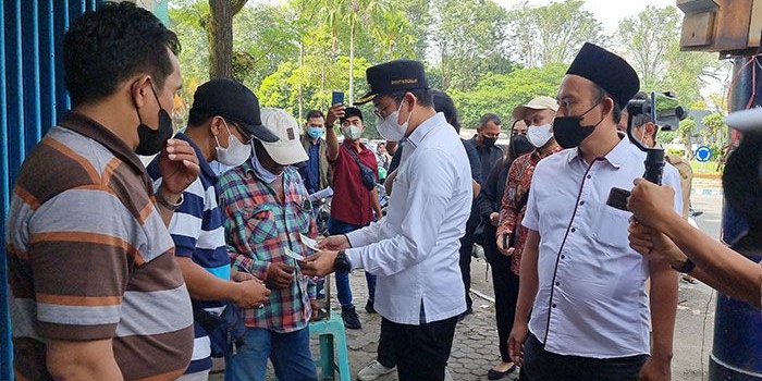 Bupati Bangkalan, R Abdul Latif Amin Imron, saat menyerahkan voucer bantuan untuk pedangan kaki lima dan UMKM.