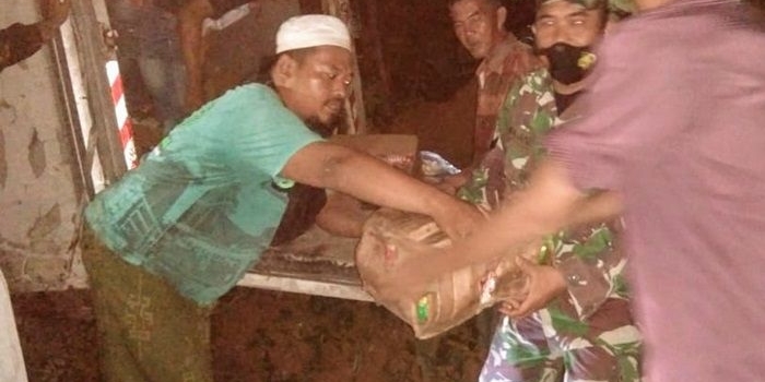 Petugas dibantu warga sedang mengevakuasi sosis dari mobil box. 