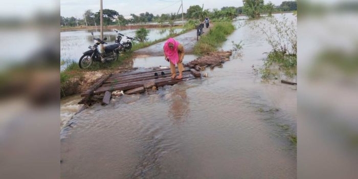 Salah satu warga kesulitan saat hendak melewati jembatan darurat.