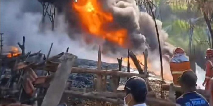 Petugas Damkar Tuban saat berupaya memadamkan kebakaran rumah warga yang dijadikan lokasi pengolahan BBM ilegal.