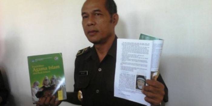 Kasi Intel Kejaksaan saat menunjukkan salah satu halaman buku Agama Islam yang kata-katanya dinilai mengandung ajaran radikal. (Arif Kurniawan/BANGSAONLINE)