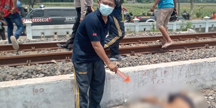 Petugas saat mengevakuasi korban tewas ditabrak kereta api di Jombang.