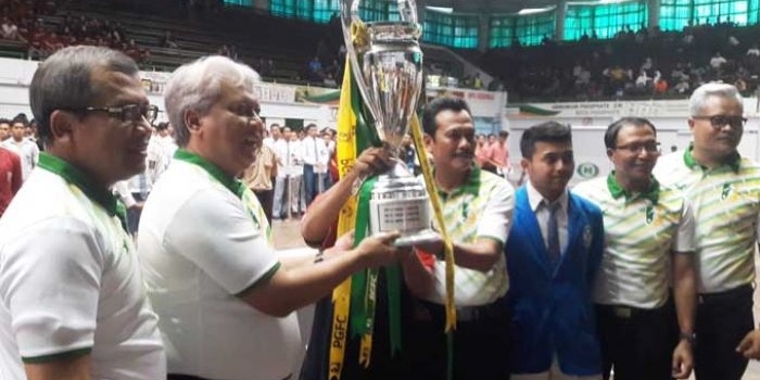 Direktur Utama PG Nugroho Christijanto didampingi Wabup Moh. Qosim menunjukkan piala bergilir PGFC. foto: SYUHUD/ BANGSAONLINE