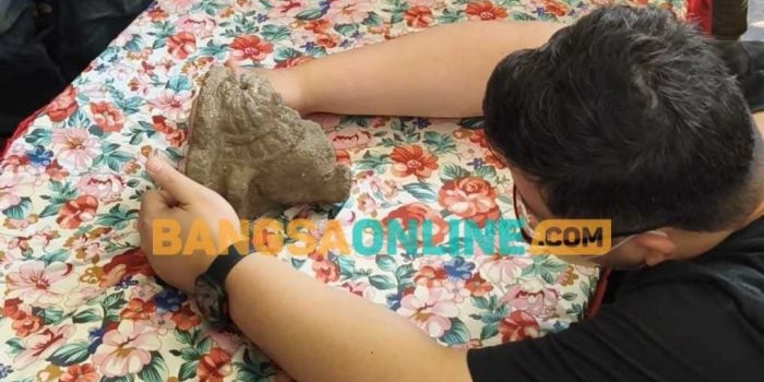 Bupati Kediri Dhito saat memegang arca Fragmen Kepala Ganesha yang sudah kembali lagi. Foto: Muji Harjita/BANGSAONLINE.com