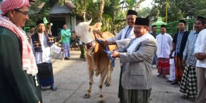 Bupati MadiunH Muhtarom SSos menyerahkan sapi kurban kepada panitia di Masjid Al-Basmallah. Foto:dhanny/BangsaOnline