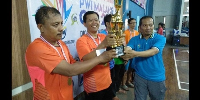 Taufik, Sekretaris PWI Malang Raya saat menyerahkan Piala Wali Kota Malang Cup 2018 kepada sang Juara Polres Malang Kota, Sabtu (24/11). Foto: IWAN I/BANGSAONLINE