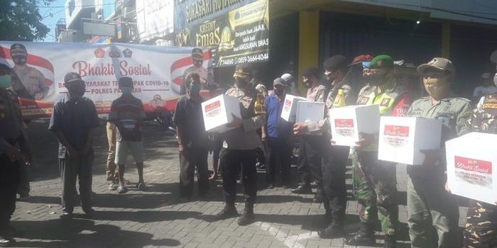 Kapolres Pasuruan bersama Banser dan relawan, membagikan paket sembako bagi warga yang terdampak Covid-19 di sekitar Plaza Bangil.
