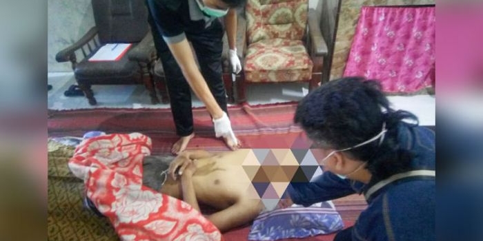 Petugas saat melakukan pemeriksaan luar terhadap jenazah korban. foto: AAN AMRULLOH/ BANGSAONLINE