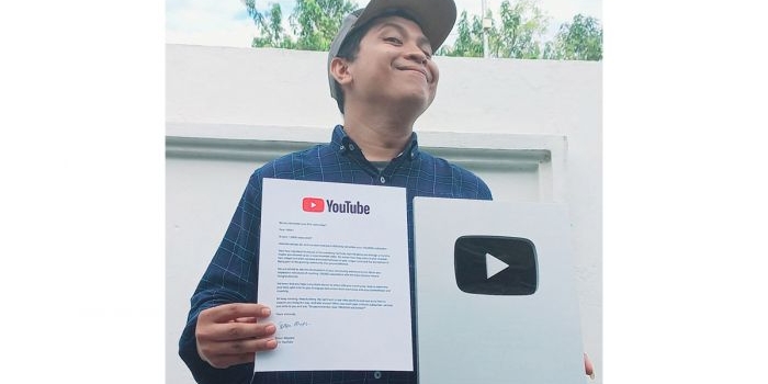 Tamam Mubarok, Pemilik Channel Mamat On Duty, memamerkan silver play button dari YouTube.