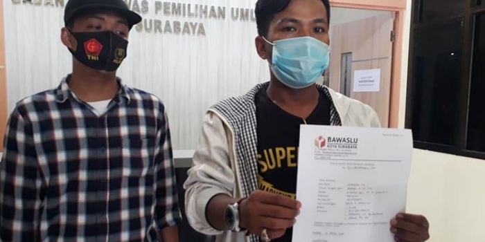 Zainuddin, Ketua Gerakan Mahasiswa Jaringan Kemandirian Nasional (GM Jaman) menunjukkan Tanda Bukti Penyampaian Laporan no, 27/LP/PW/Kota/1601/X/2020 di kantor Bawaslu Surabaya. foto: ist.