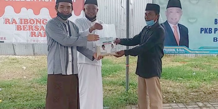 R. Imron Amin (kiri) bersama Syafiuddin menyerahkan sembako bersama secara simbolis kepada masyarakat terdampak Covid-19. foto: FAUZI/ BANGSAONLINE