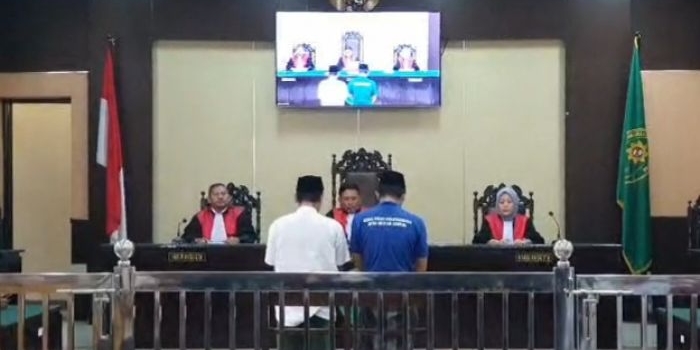 Kedua terdakwa kasus penganiayaan guru saat mengikuti sidang di PN Sampang