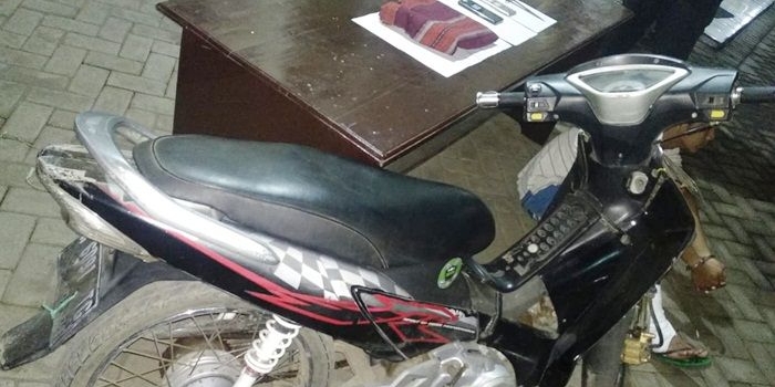Tersangka pembunuh Metty alias Slamet Pujianto (di balik motor) dengan kaki kanan terbalut akibat berusaha kabur. Petugas juga mengamankan barang bukti berupa sangkur berada di atas meja.