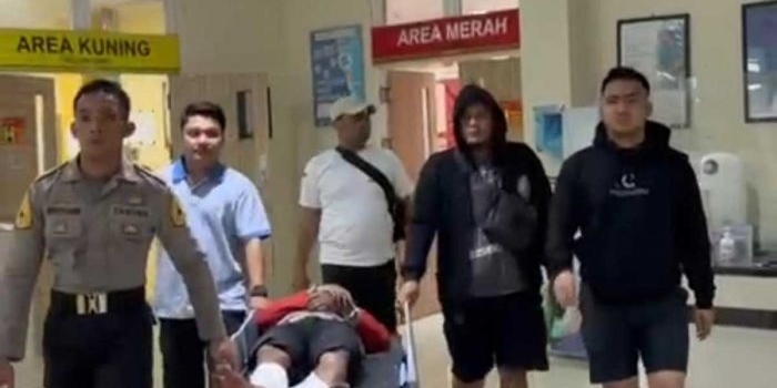 Petugas dari Polres Gresik ketika membawa pelaku ke rumah sakit setelah kakinya ditembak karena berusaha kabur saat akan ditangkap. Foto: Ist