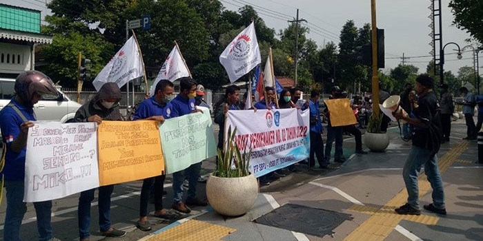 Puluhan buruh saat menggelar demo di depan kantor Disnaker Jombang.