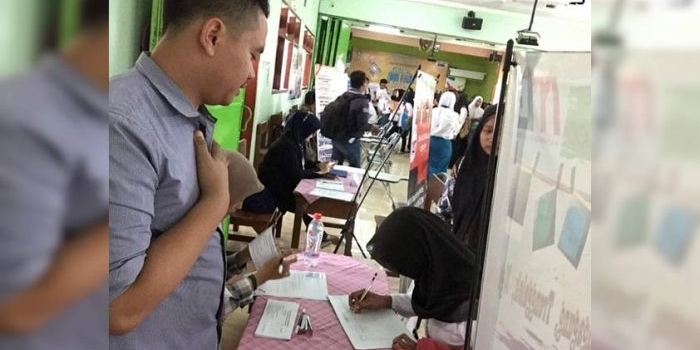 Salah satu pencari kerja saat mendaftar di salah satu perusahaan yang membuka lowongan di SMK PGRI 2 Kediri. foto: ARIF KURNIAWAN/ BANGSAONLINE
