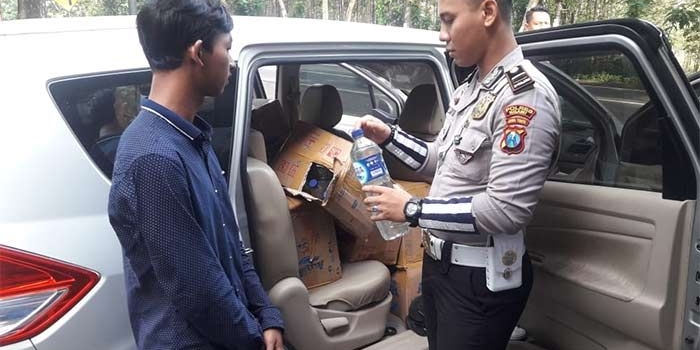 Kanit Turjawali Satlantas Polres Ngawi saat mengecek miras. foto: ZAINAL ABIDIN/ BANGSAONLINE