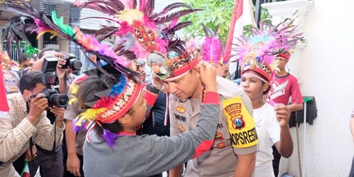 Ika dan Vina mendapatkan kehormatan memasangkan ikat kepala khas Papua dari bulu burung Cendrawasih ke Kapolresta Sidoarjo, Senin (26/8/2019) sore.