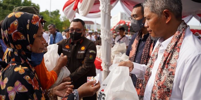 SVP of Supporting SIG Muchamad Supriyadi (kanan) menyerahkan paket sembako murah kepada warga Rembang pada acara Pasar Murah dan Bazar UMKM BUMN di Alun-Alun Rembang, Jawa Tengah. Foto: Ist.