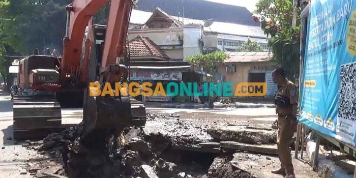 Ekskavator saat melakukan pengerukan untuk pembangunan gorong-gorong. Foto: BAMBANG DWI JULIANTO/BANGSAONLINE