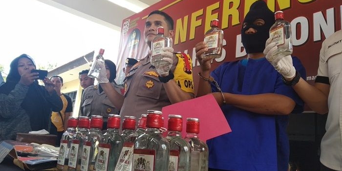 BARANG BUKTI: Kapolres Bojonegoro AKBP Ary Fadli menunjukkan vodka KW yang disita dari tersangka.