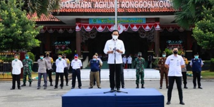 Bupati Pamekasan H. Baddrut Tamam saat memimpin apel pasukan dalam rangka tindak lanjut pemindahan pasien Covid-19 isolasi mandiri (isoman) ke tempat isolasi terpusat (isoter) di Lapangan Nagara Bhakti Mandhapa Aghung Ronggosukowati, Rabu (18/8/2021). (foto: ist)