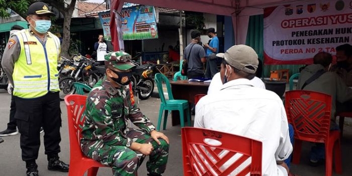 Dandim 0809/Kediri, Letkol Kav. Dwi Agung Sutrisno, S.E., M.Si., (Han) saat berdialog dengan salah satu warga yang terjaring operasi yustisi di Jalan Bandar Ngalim. (foto: ist).