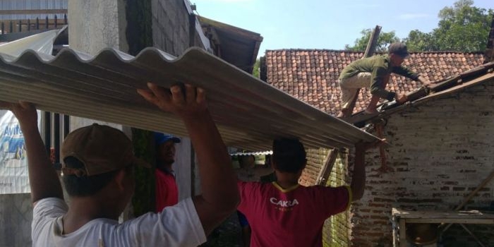 Warga di Kecamatan Kunjang, Kabupaten Kediri, saat bergotong royong memperbaiki atap rumah yang rusak akibat diterjang angin puting beliung. Foto: Ist