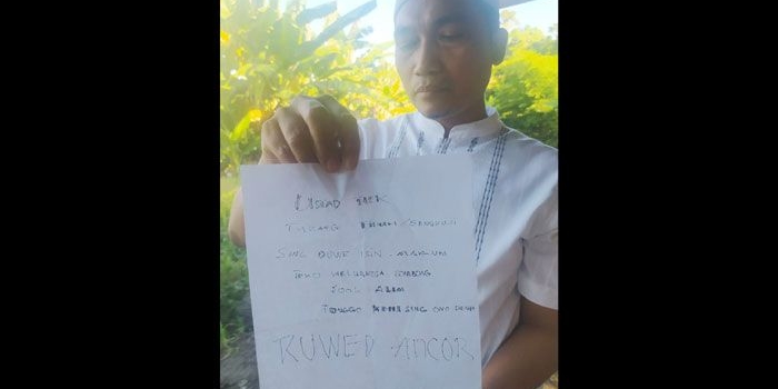 Ustaz Ansori sedang menunjukkan surat berisi penghinaan yang ditujukan kepadanya.