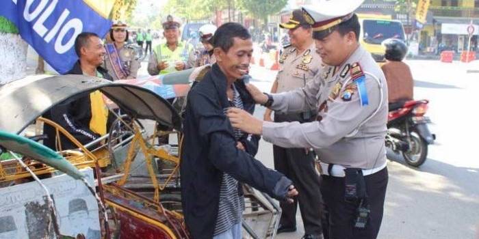 Kasatlantas Polres Pacitan, AKP J Nugroho saat memberikan jaket dan helm kepada pengguna jalan yang dinilai tertib. foto: yuyun/ BANGSAONLINE