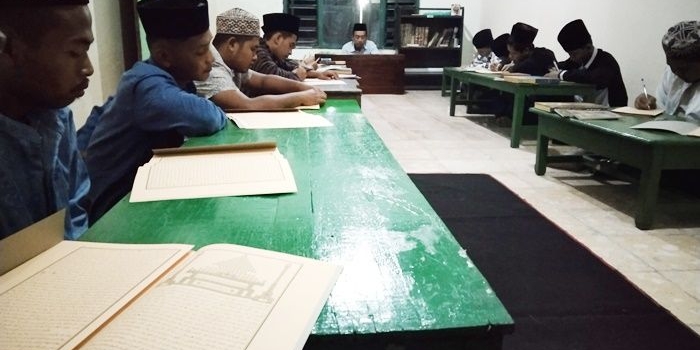 Para santri sedang mengaji kitab usai Salat Tarawih setiap bulan Ramadan.