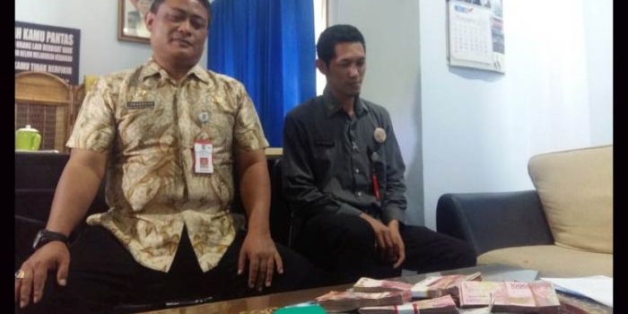 Kepala Inspektorat Lumajang saat menunjukkan hasil OTT senilai Rp 157 juta rupiah di satu Kecamatan Kunir. foto: IMRON/ BANGSAONLINE