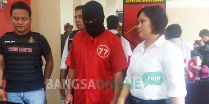 Tersangka pencabulan didampingi Kanit PPA Polrestabes Surabaya. foto:: ekoyono/ BANGSAONLINE