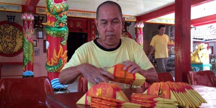 Pengurus Vihara Avalokitesvara Pamekasan sedang menyiapkan uang dewa. (Taufiqurrahman/Kompas.com)