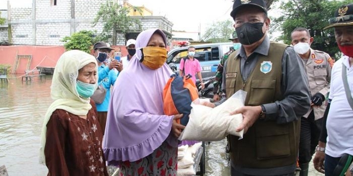 Bupati Lamongan Fadeli saat menyerahkan bantuan sembako kepada warga terdampak banjir di Desa Putatbangah Kecamatan Karangbinangun.