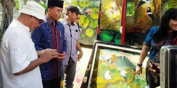 Rasiyo berbincang dengan M Anis seniman lukis yang didatanginya di Bantaran Sungai Ketabang Kali. 