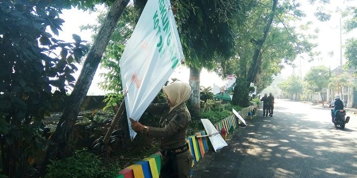 Petugas saat membersihkan ratusan banner di Jalan Hayam Wuruk. Foto: YUDI EP/BANGSAONLINE
