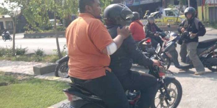 Rizal Ghozali (dibonceng) yang tangannya dibalut perban usai dibacok perampok. (foto: nanang ichwan/BANGSAONLINE)