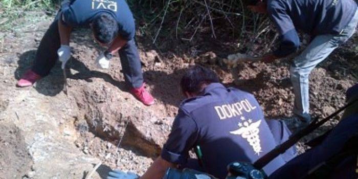 Tim DVI Polda Jatim ketika menggali kuburan berisi tenggkorak manusia di hutan jati Desa Surowiti, Panceng. (foto: syuhud/BANGSAONLINE)