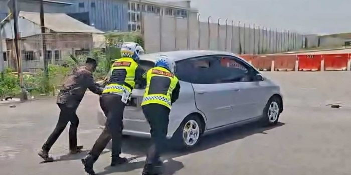 petugas-satlantas-polres-gresik-dorong-mobil-mogok-pemudik-di-jembatan-sembayat