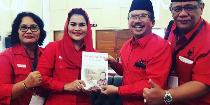 Bambang DH sat menyerahkan sebuah buku berjudul 